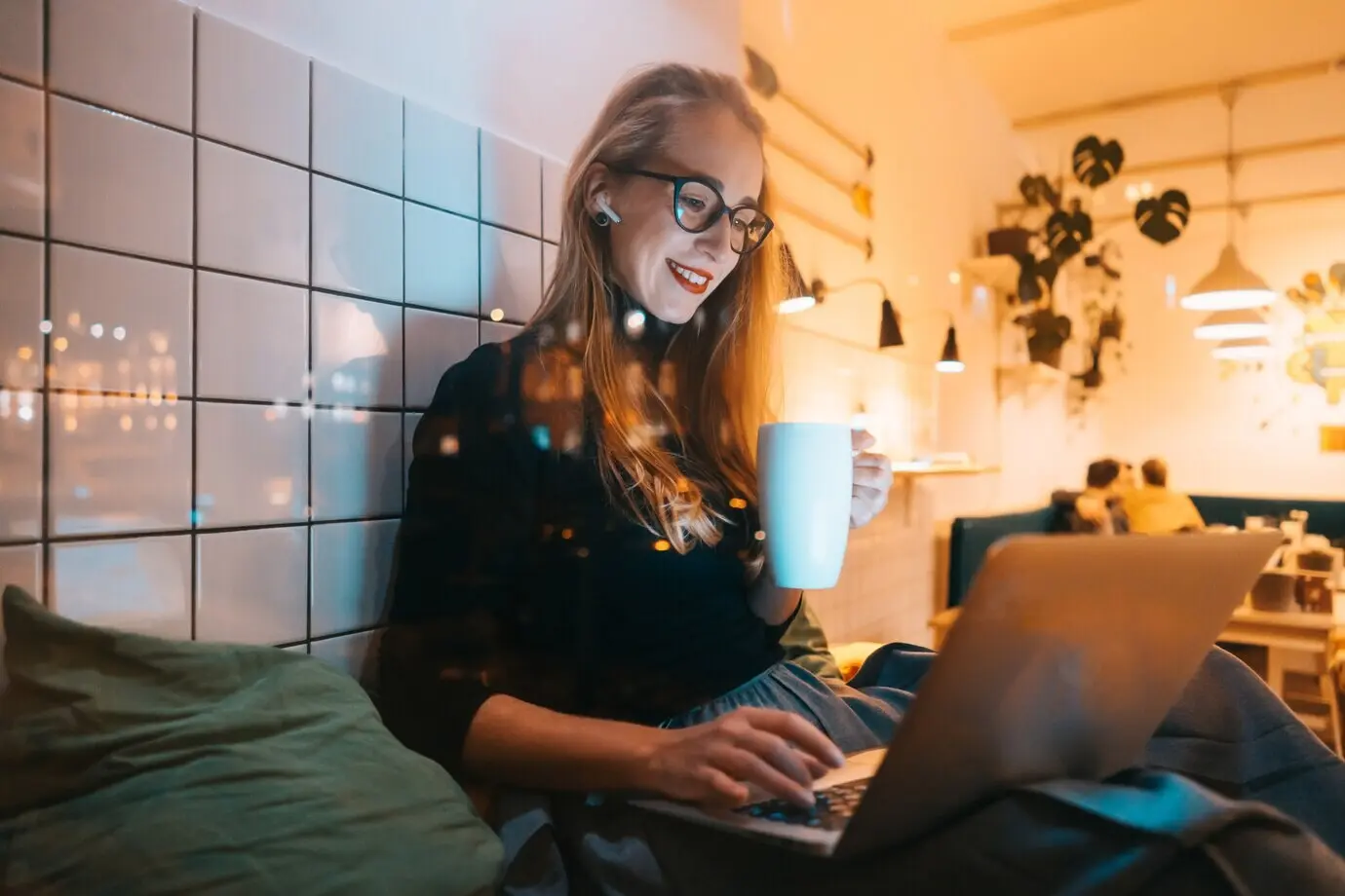 Eine Frau arbeitet am Abend in einem Café.
